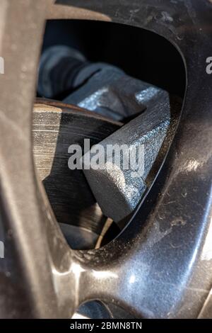 The detailed look at a disc brake of modern car. Brake pads on brake disc, close up. Stock Photo