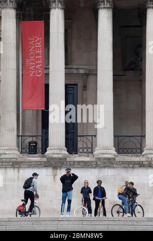 London, UK: sight-seers and cyclists in Trafalgar Square stop for photos and mostly manage to follow social-distancing advice. Prime Minister Boris Johnson is poised to announce some relaxation of the rules. Anna Watson/Alamy Live News Stock Photo