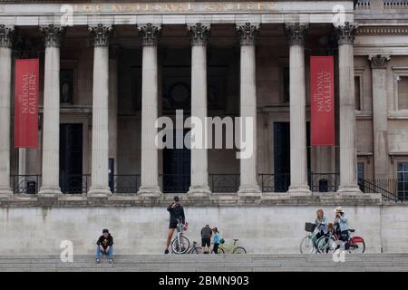 London, UK: sight-seers and cyclists in Trafalgar Square stop for photos and mostly manage to follow social-distancing advice. Prime Minister Boris Johnson is poised to announce some relaxation of the rules. Anna Watson/Alamy Live News Stock Photo