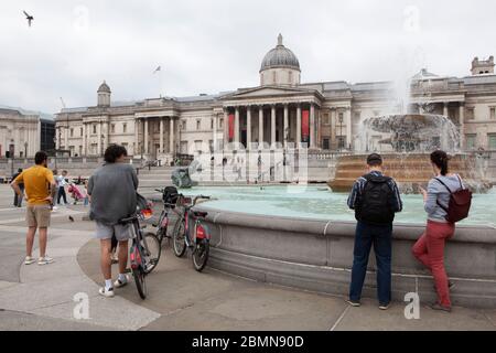 London, UK: sight-seers and cyclists in Trafalgar Square stop for photos and mostly manage to follow social-distancing advice. Prime Minister Boris Johnson is poised to announce some relaxation of the rules. Anna Watson/Alamy Live News Stock Photo