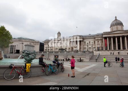 London, UK: sight-seers and cyclists in Trafalgar Square stop for photos and mostly manage to follow social-distancing advice. Prime Minister Boris Johnson is poised to announce some relaxation of the rules. Anna Watson/Alamy Live News Stock Photo