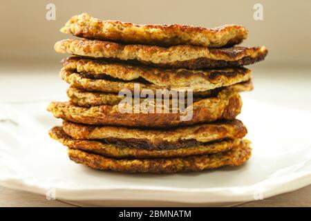 Stack of vegetable Zucchini fritters served on white plate close up. Stock Photo