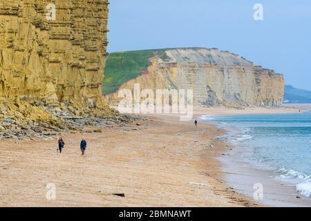 West Bay, Dorset, UK.  10th May 2020.  UK Weather:  The beach at the seaside resort of West Bay in Dorset is almost deserted on a cold windy afternoon during the coronavirus lockdown.  Picture Credit: Graham Hunt/Alamy Live News Stock Photo