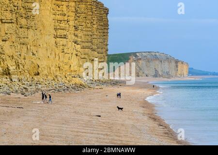 West Bay, Dorset, UK.  10th May 2020.  UK Weather:  The beach at the seaside resort of West Bay in Dorset is almost deserted on a cold windy afternoon during the coronavirus lockdown.  Picture Credit: Graham Hunt/Alamy Live News Stock Photo