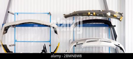 Bumpers hanging in auto service shop after painting and drying Stock Photo