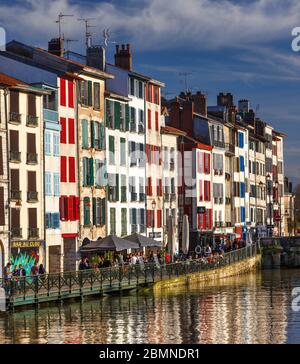 The Nive river and the Galuperie quay in the 'Small Bayonne' area. French Basque country Atlantic Pyrenees Aquitaine France. Bar terrace. Bars. People Stock Photo
