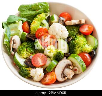 Flavorful Italian salad with marinated vegetables, mushrooms, cherry tomatoes and Parmesan. Isolated over white background. Stock Photo