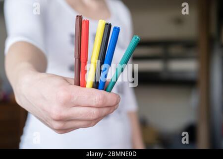 Colored markers in a female hand, on a blurred background, in natural light. Stock Photo