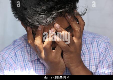 Close up of sad man covering face with hand. Stock Photo