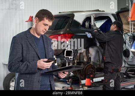Auto mechanic and technician working in repair shop Stock Photo
