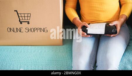 Young woman opening paper box - Girl bought online products during isolation quaratine - Shopping online, e-commerce and shipping concept - Main focus Stock Photo