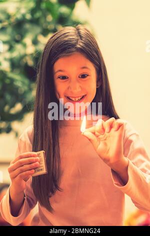 Girl playing with matches. Dangerous situation at home. A small child plays with matches, a fire, a fire flares up, danger, child and matches, lucifer Stock Photo