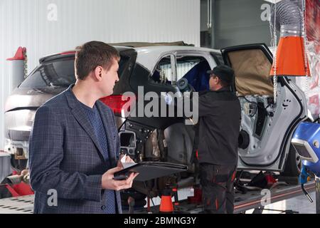 Auto mechanic and technician working in repair shop Stock Photo