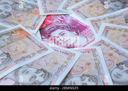 Fifty Pound note surrounded by Ten Pound Notes revelling the queens head, £50, £10 Stock Photo