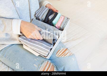 A girl holds a basket with assorted and clean socks. White background.