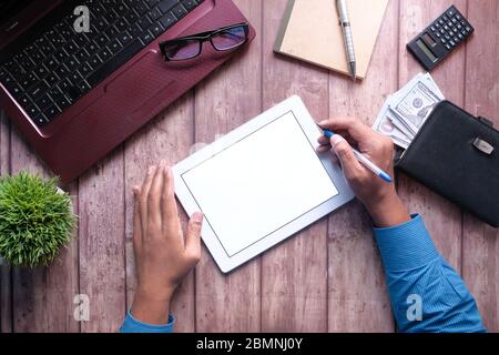 young man working on digital tablet with laptop and notepad on table  Stock Photo