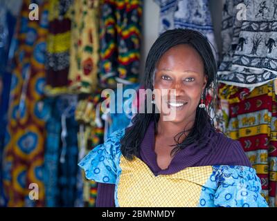 Senegalese woman poses for a picture at her fabric stall in Dakar ...