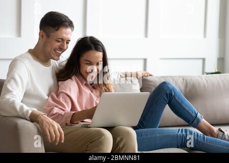 Happy young couple using laptop together, having fun on weekend Stock Photo