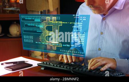 Hacker typing on the keyboard and Bitcoin mining on hologram screen on desk. Digital crypto currency, cyber money and digital banking concept. Stock Photo