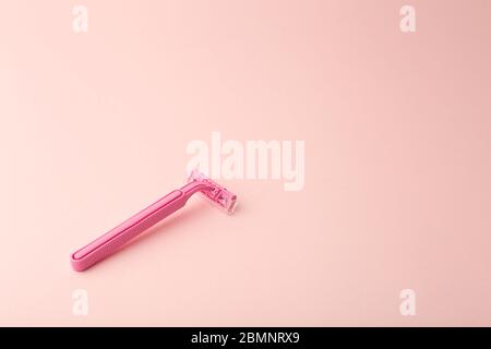 Female shaving razor on a pink background. Skin care, cosmetics, and female beauty concept. Stock Photo
