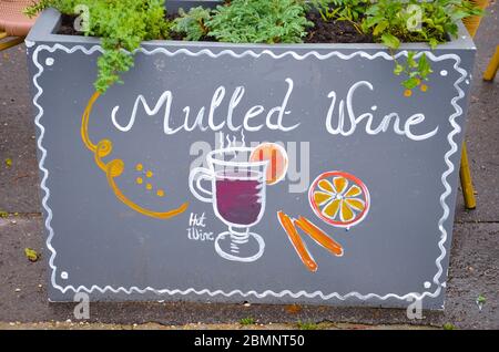 Handwritten sign mulled and simple drawing of a mulled wine glass with orange and cinnamon. Original ad attracting people to buy hot wine in the winter season. Stock Photo