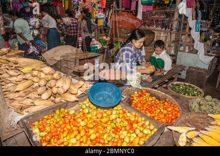 Bagan Myanmar October 29 2013; vendors in shop with woman and son preparing and selling typical Burmese natural fresh food vegetables and fruit