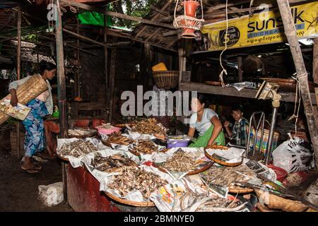 Bagan Myanmar October 29 2013; vendors in shop with woman and son preparing and selling typical Burmese dried seafood options.