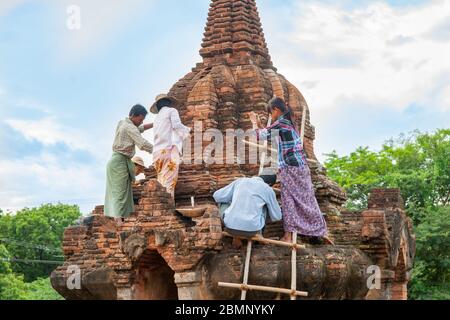 Bagan Myanmar - October 29 2013; Workers on an historic brick stupa repairing, resoring and recording the restoration