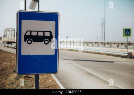 Road sign bus stop on the background of sky and road. Stock Photo