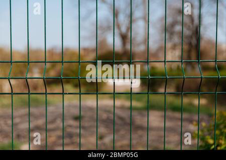 Steel grill fence with blurred wire background. Stock Photo