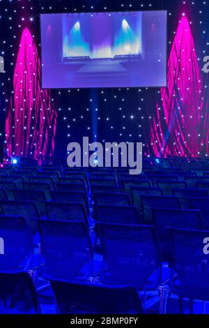 Blue chairs with a big screen in a hall Stock Photo