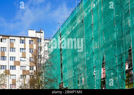 green safety net on scaffolding at the facade of an apartment house Stock Photo