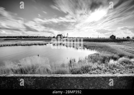 Old harbor of a former island in the Netherlands. Old buildings, the harbor mouth and the jetties can still be seen. But you can no longer enter. The Stock Photo