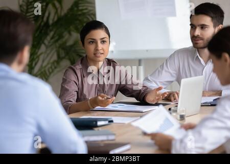 Attractive indian ethnic businesswoman with businessman partner talking in boardroom. Stock Photo