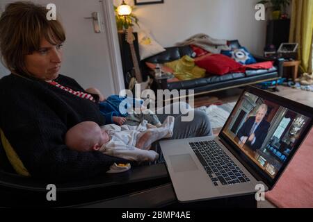 West Norwood, UK. 10th May 2020. A women with two new born twins watches the BBC on a laptop as the UK Prime Minister, Boris Johnson addresses the nation with new phases of the Coronavirus lockdown. Following the announcement, Boris Johnson said it is 'not the time to end the lockdown' (photo by Sam Mellish / Alamy Live News) Stock Photo