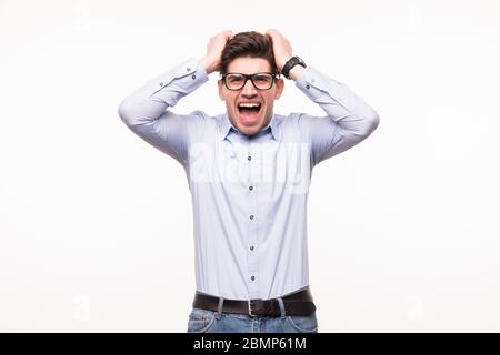 Emotional scared brunet male has dark stubble, looks with frightened expression as sees something awful in front, looks nervously into camera, demonst Stock Photo