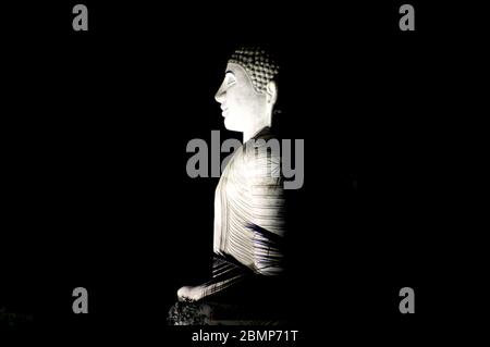 An illuminated statue of lord Buddha in Kandy, Sri Lanka. This massive stone made statue is a major attraction of Kandy. Stock Photo
