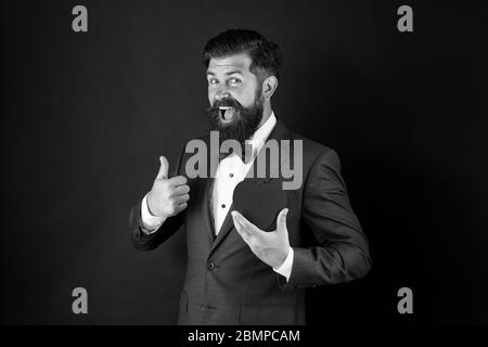 Fall in love. Celebrate love. Trust me. Happy valentines day. Tuxedo man hold red heart. Love concept. Passionate mature lover hipster in formal suit. Businessman with bow tie. Romantic greeting. Stock Photo