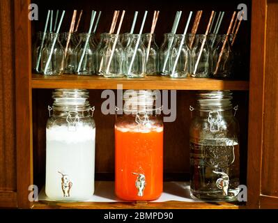 Collection of glass jars with different beverages in display and glasses with straws during a party Stock Photo