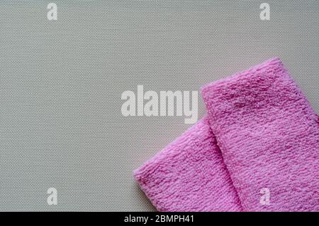 Soft pink towels on a white textured background. Colorful bath towels. Health and hygiene care. View from above. Place for text. Stock Photo