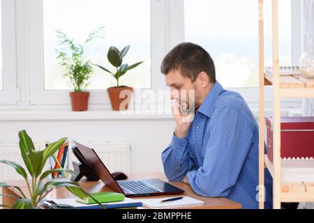 A typical weekday office specialist working on a computer while sitting at a desk Stock Photo