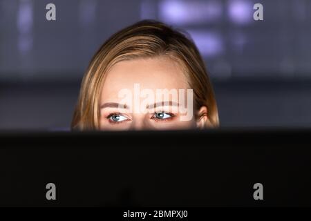 Close up of young female working on desktop pc late at night at home office, can not sleep, addict news about coronavirus or sharing social media. Sel Stock Photo