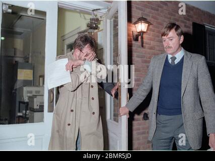 Wall Street securities analyst Joseph Pikul, left, cover his face after his arrest on a murder charge of his wife, Diane Whitmore, at the New York State police barracks in New Windsor, NY on October 30, 1987. Photo by Francis Specker Stock Photo