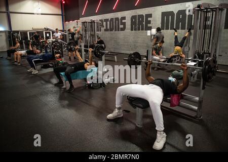 cologne germany 11th may 2020 a woman with a mouth guard is training on a leg press in a fitness studio of the mcfit chain in nrw the first gyms have reopened