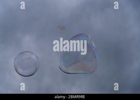 Big soap bubbles against the background of cloudy sky. Stock Photo