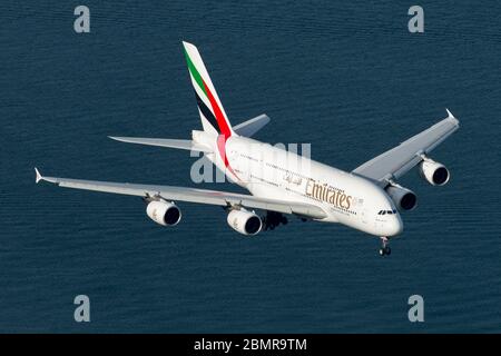 Emirates Airline Airbus A380 flying over Botany Bay waters on approach to Sydney International Airport in Australia. A380-800 aircraft A6-EEG flying.