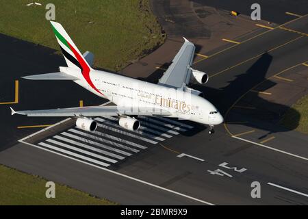 Emirates Airlines Airbus A380 aircraft over Sydney International Airport runway threshold before landing. Aerial view of huge A380 airplane. Stock Photo