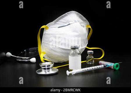 Medical healthcare concept. Diagnosis and cure of Coronavirus. stethoscope, blood test, mask and vials for diagnostic or cure of coronavirus disease medical instruments on black isolated background .  Stock Photo