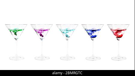 Rainbow of brightly colored drinks of single drop of color as it falls in water in crystal clear martini glasses, Virginia, United States, color Stock Photo