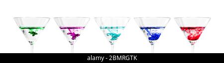 Rainbow of brightly colored drinks of single drop of color as it falls in water in crystal clear martini glasses, Virginia, United States, color Stock Photo